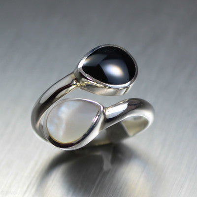 Two teardrops of Mother of pearl and black shell wrap around silver ring