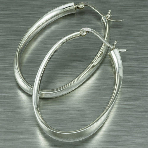 Large distorted oval sterling silver hoop earrings.