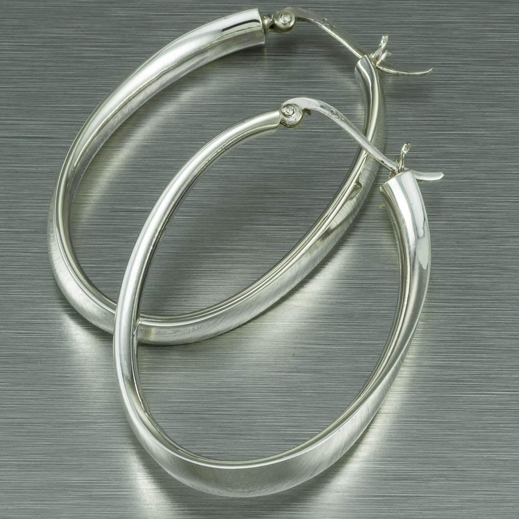 Large distorted oval sterling silver hoop earrings.