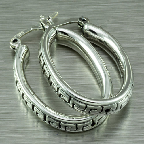 Large, oval hoop earrings with a Greek key motif design